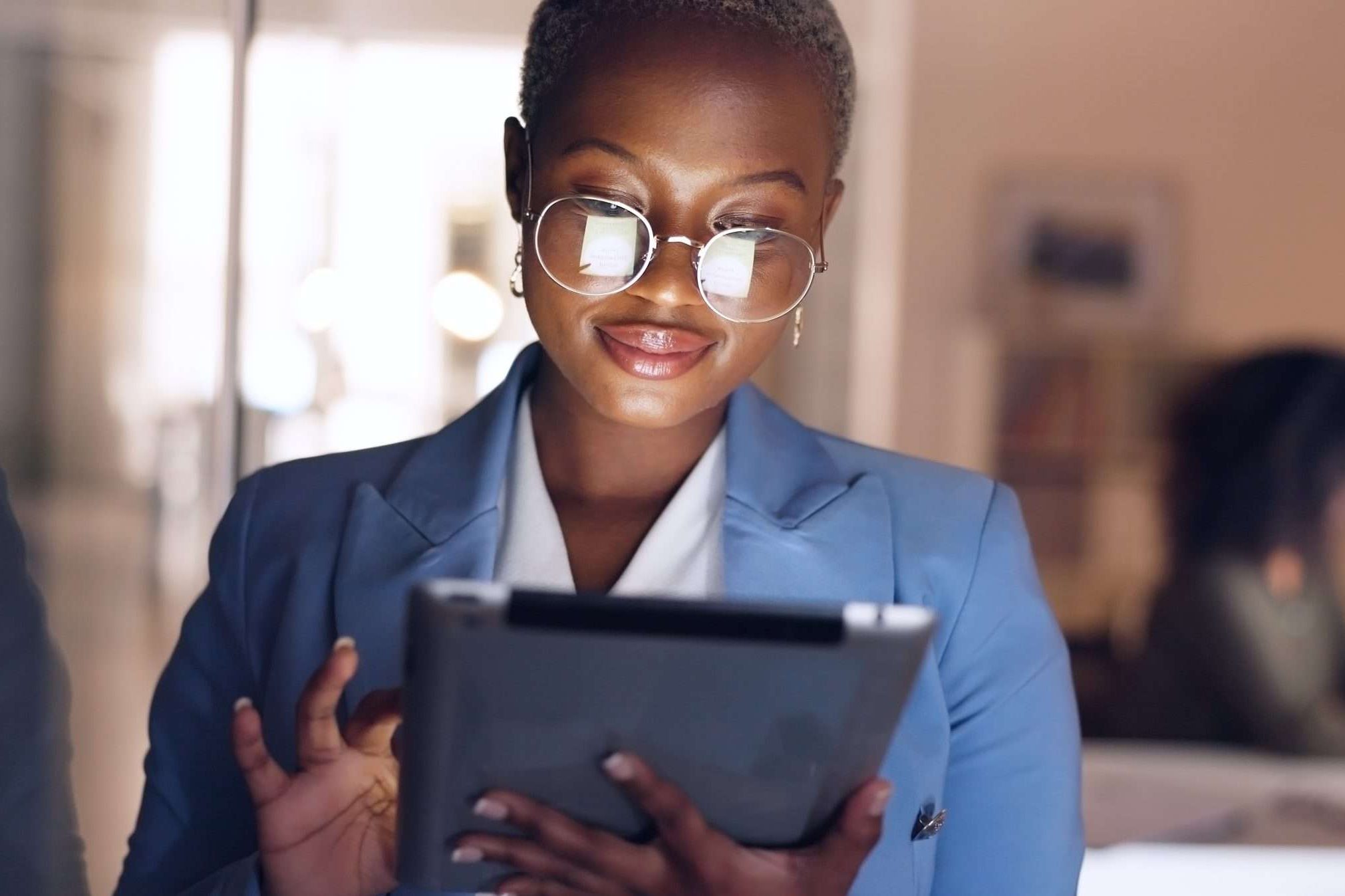 Black woman, tablet and business in office at night working overtime, corporate deadline or online research. Social media, internet surfing and female from Nigeria on digital tech in dark office.