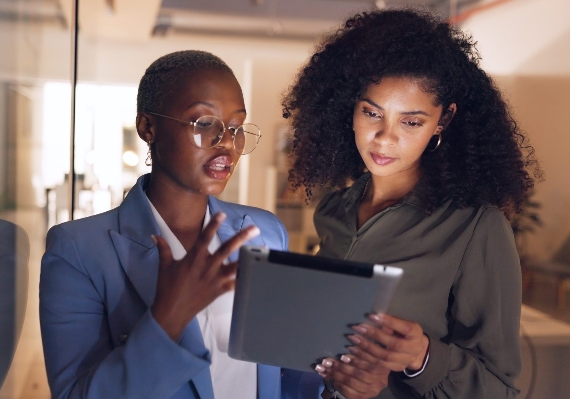 Black women, business and tablet in discussion or meeting for corporate strategy, planning or collaboration at office. African woman executive talking to employee on touchscreen technology at work