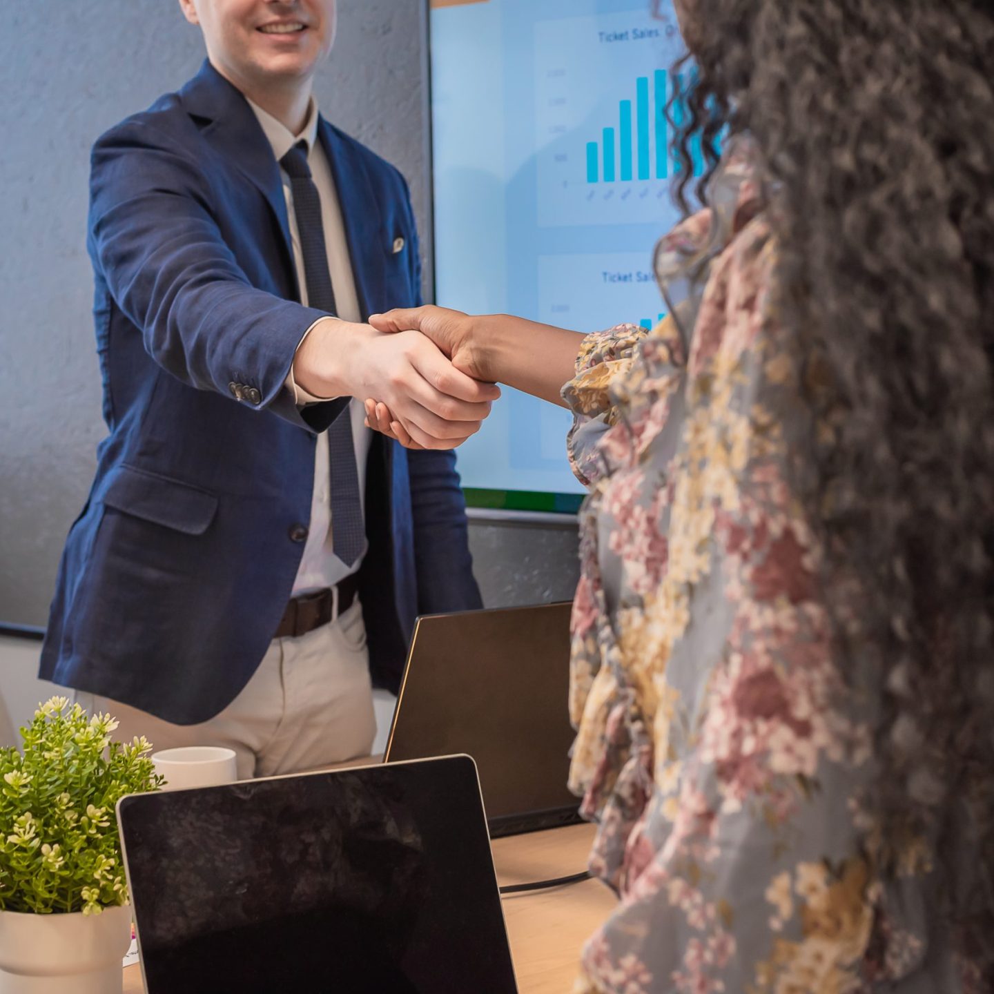 Business man shake hands with business women agreeing on partnerships or introducing themselves for first time meet.