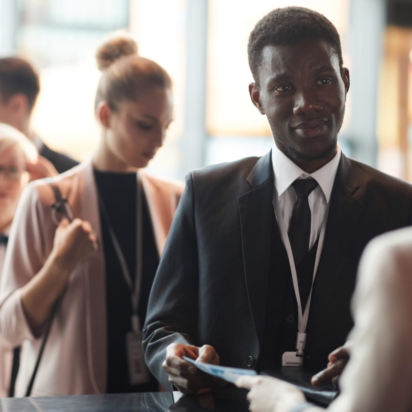 Young African businessman standing near the registration and registering at business conference