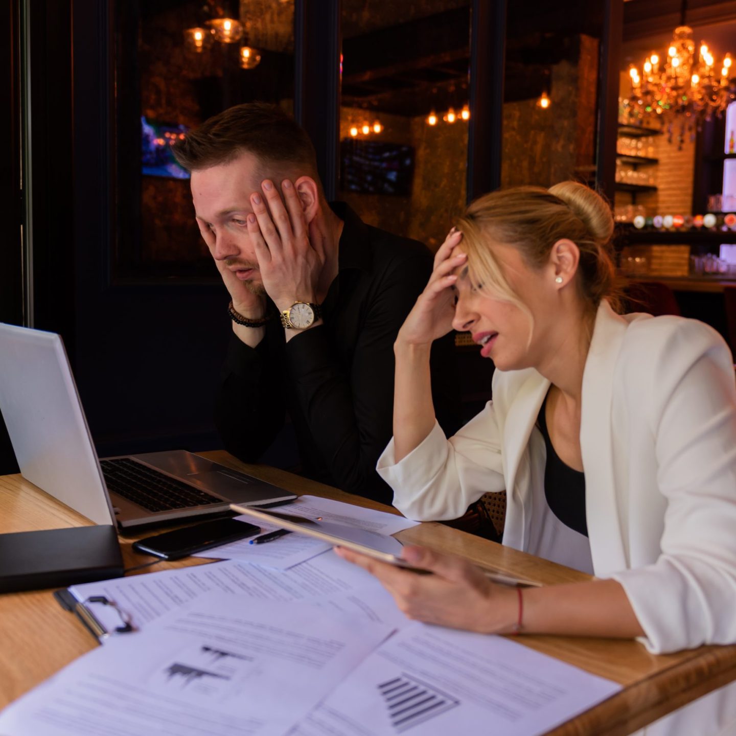 Shot of a man and woman going through paperwork together during a meeting in a cafe