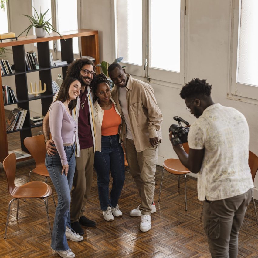 Sixth Hive Media photographer recording young entrepreneurs for social media, group of multiracial people in modern office